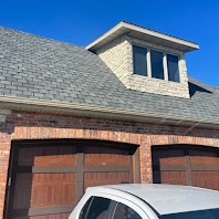Architectural shingle roof on a brick home with dormer and three-car garage
