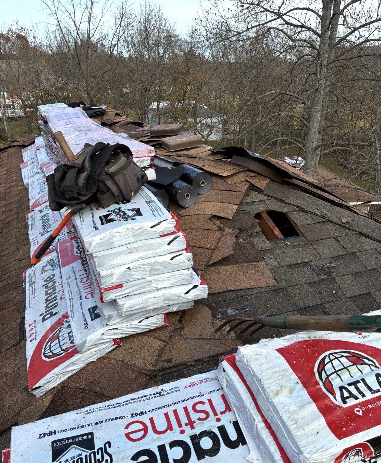 Power Plus Roofing crew mid-install with Atlas Pinnacle shingles staged on the roof