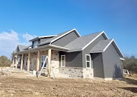 Modern home with new gray siding and stone accents installed by Power Plus Roofing
